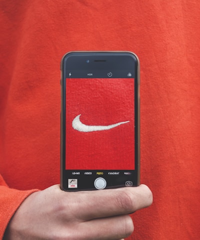 person holding iPhone taking picture on Nike label