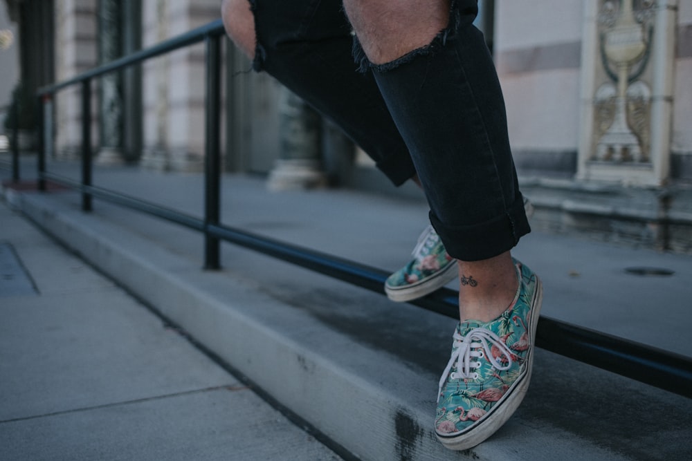 person wearing green-and-white low-top sneakers