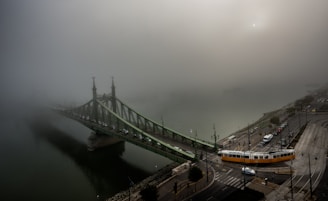 train towards gray concrete bridge covered by white clouds