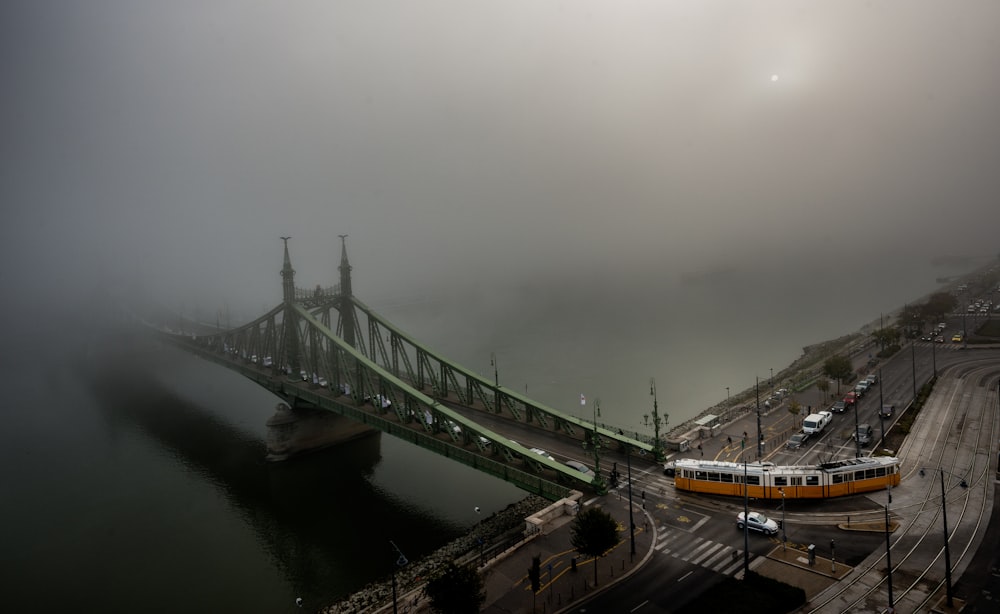 Zug zur grauen Betonbrücke, die von weißen Wolken bedeckt ist