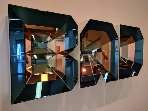 Custom decorative mirror installation with geometric patterns and subtle lighting.