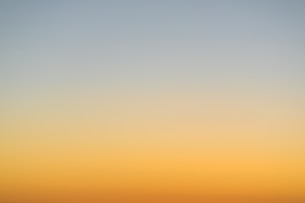 a plane flying in the sky at sunset