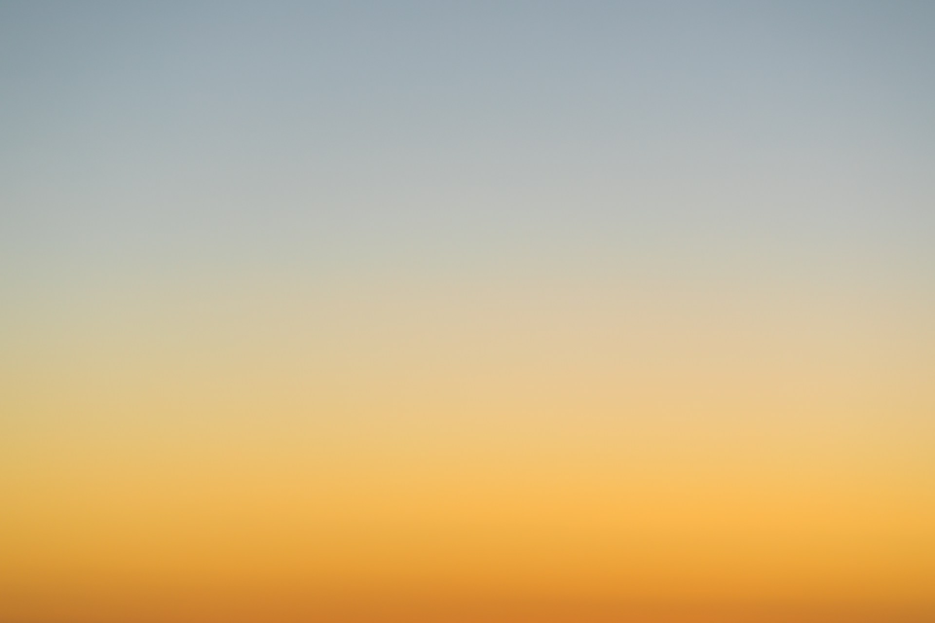 a plane flying in the sky at sunset