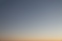 a plane flying in the sky at sunset