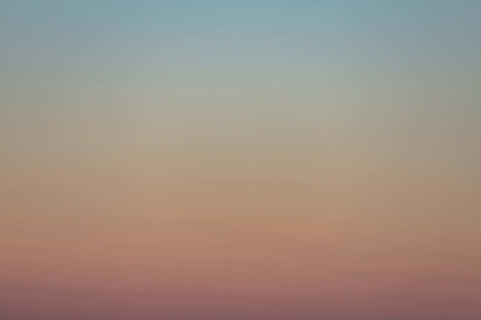 a plane flying in the sky at sunset