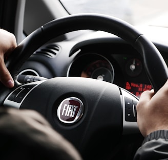 person riding FIAT car during daytime