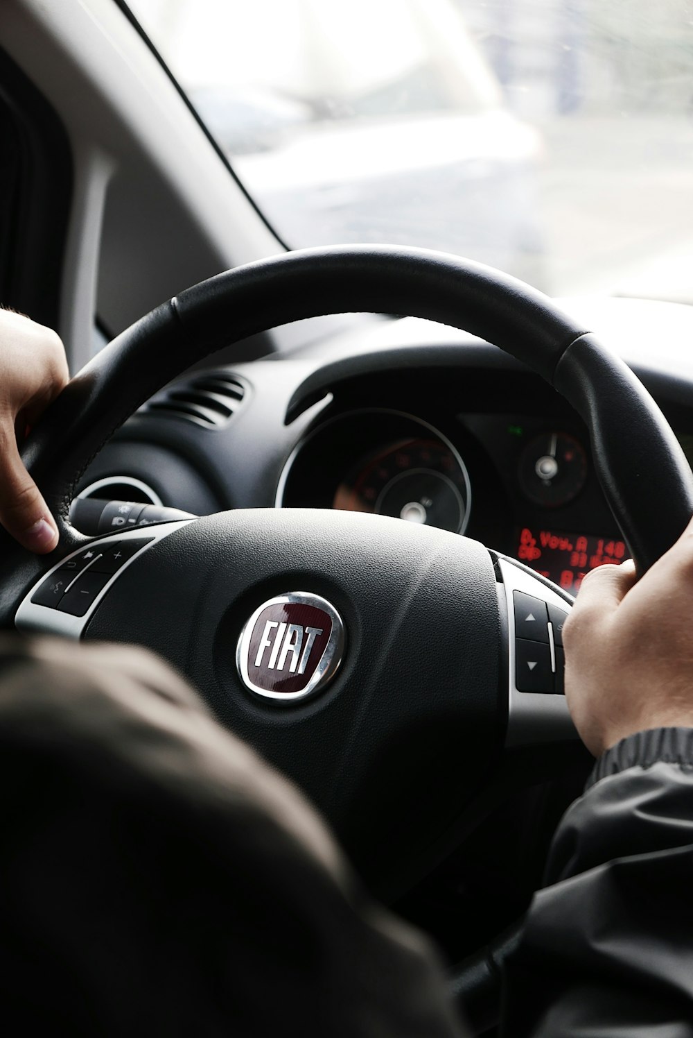 person riding FIAT car during daytime