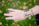 Close-up of a woman wearing delicate handmade rings with a soft cream and earth-toned background.