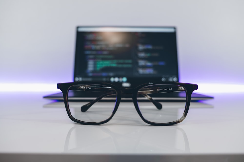 eyeglasses with black frames on white desk