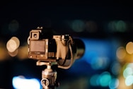 selective focus photography of black DSLR camera with stand