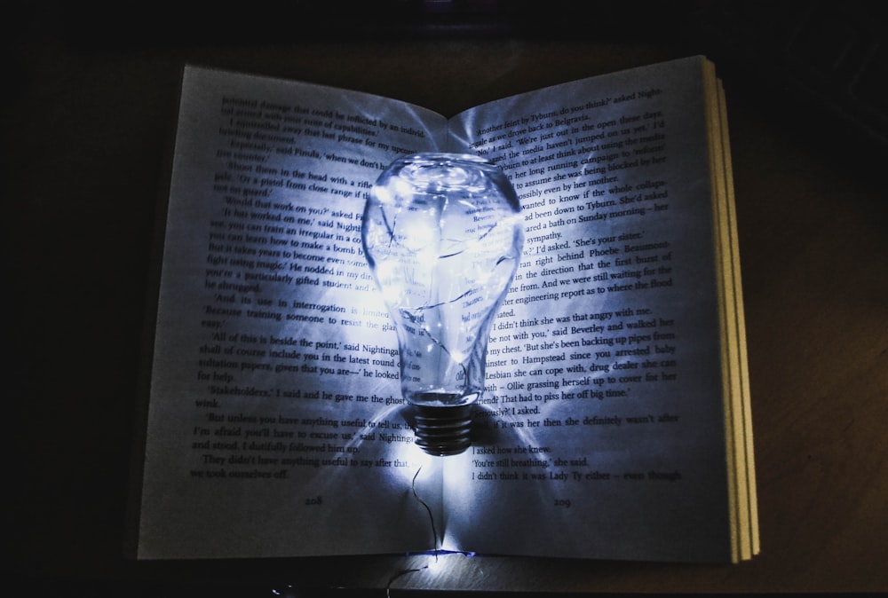 Glühbirne mit Lichterkette auf der Buchseite