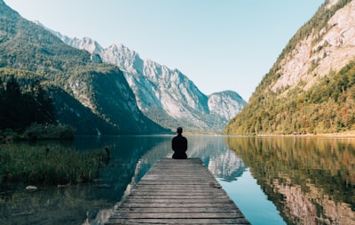 man sitting on gray dock serene zoom background