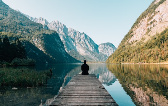 man sitting on gray dock in Berchtesgaden National Park Germany