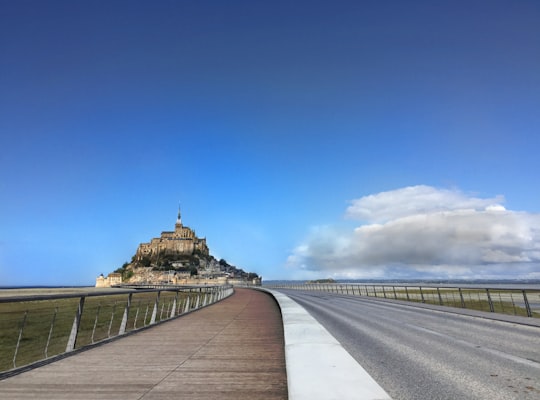 photography of black steel fence beside gray road in Mont Saint-Michel France