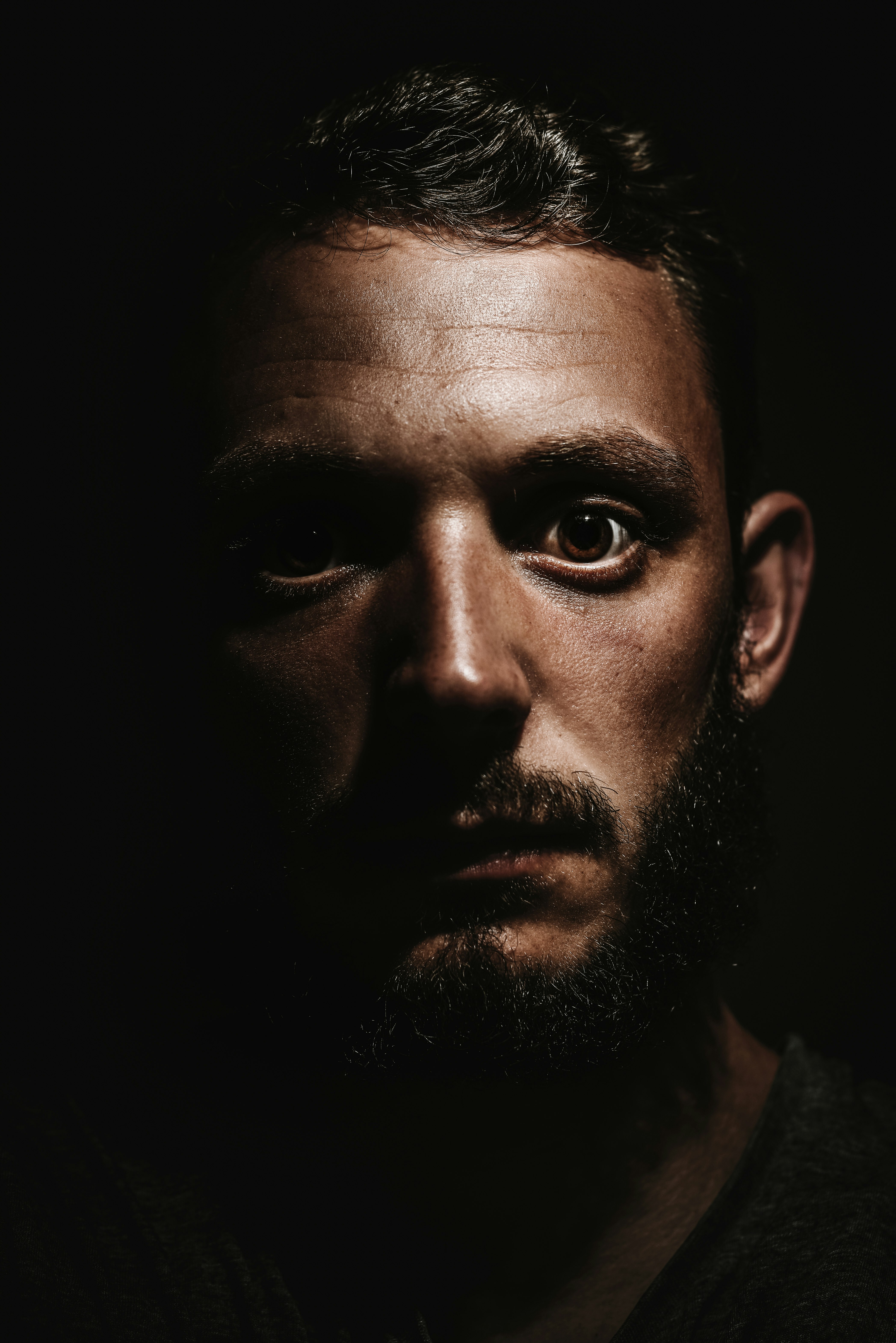 photography of man face in dimmed room