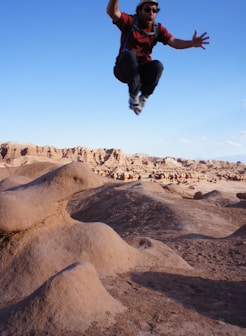 man jumped on desert during daytime
