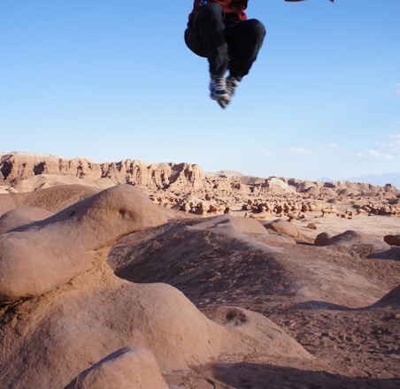 man jumped on desert during daytime