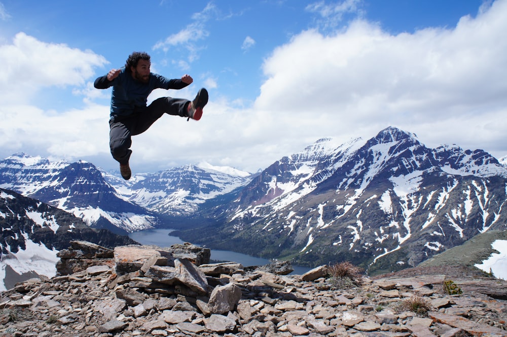 man jumping over gray stones