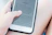 Smiling woman holding a tablet displaying the 'Before the Bible' landing page.