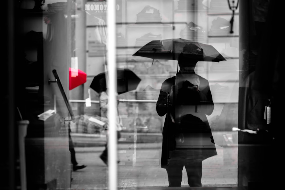 selectrive color photography of person with umbrellas