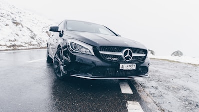 black Mercedes-Benz car on grey concrete surface