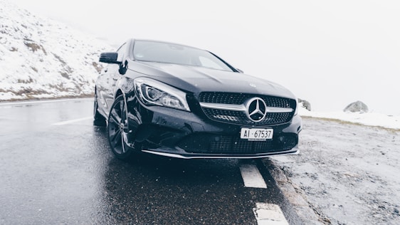 black Mercedes-Benz car on grey concrete surface