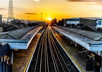 photo of brown train track at sunset