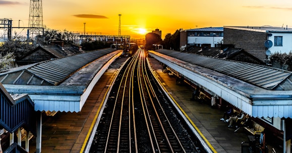 photo of brown train track at sunset