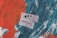 A textured abstract background with bold strokes of orange and dark teal. Two pieces of paper with the words 'Art' and 'Advocacy' written on them are prominently placed in the center.
