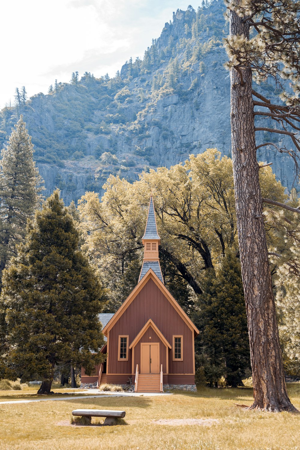 brown wooden house beside green trees near mountains during daytime