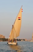A felucca boat gently sailing on the Nile River near Luxor under a clear blue sky.