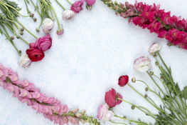 Minimalist flat lay of Aurora Pink cream surrounded by soft pink and white flowers.