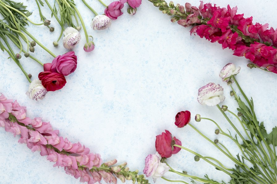 Flat lay of pastel roses, lisianthus and lavender on ivory linen