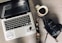 black and gray laptop computer beside black DSLR camera and white ceramic mug