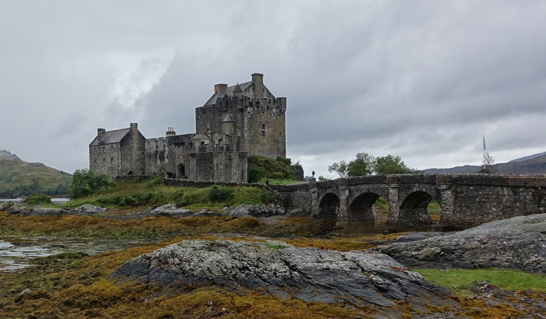 brown concrete building with trees under black sky, Eilean Donan Castle