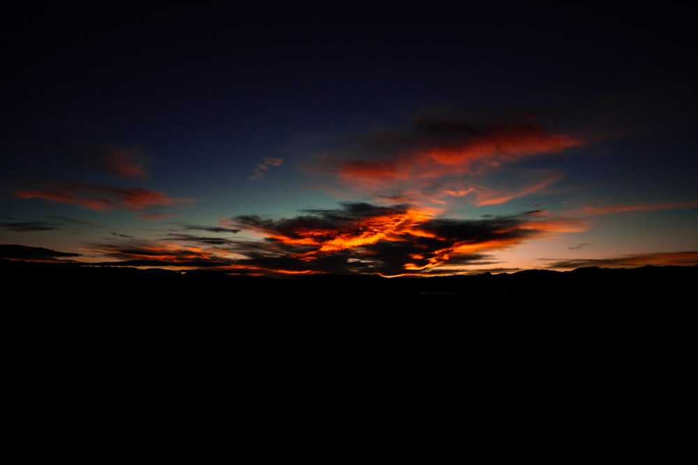 silhouette of mountains and clouds during sunset