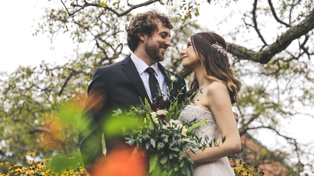 bride and groom standing near tree