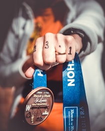 person holding Rock N Roll St. Louis half marathon medal