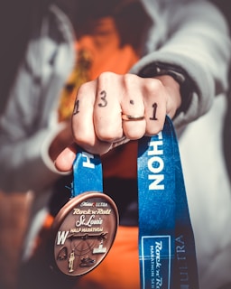 person holding Rock N Roll St. Louis half marathon medal