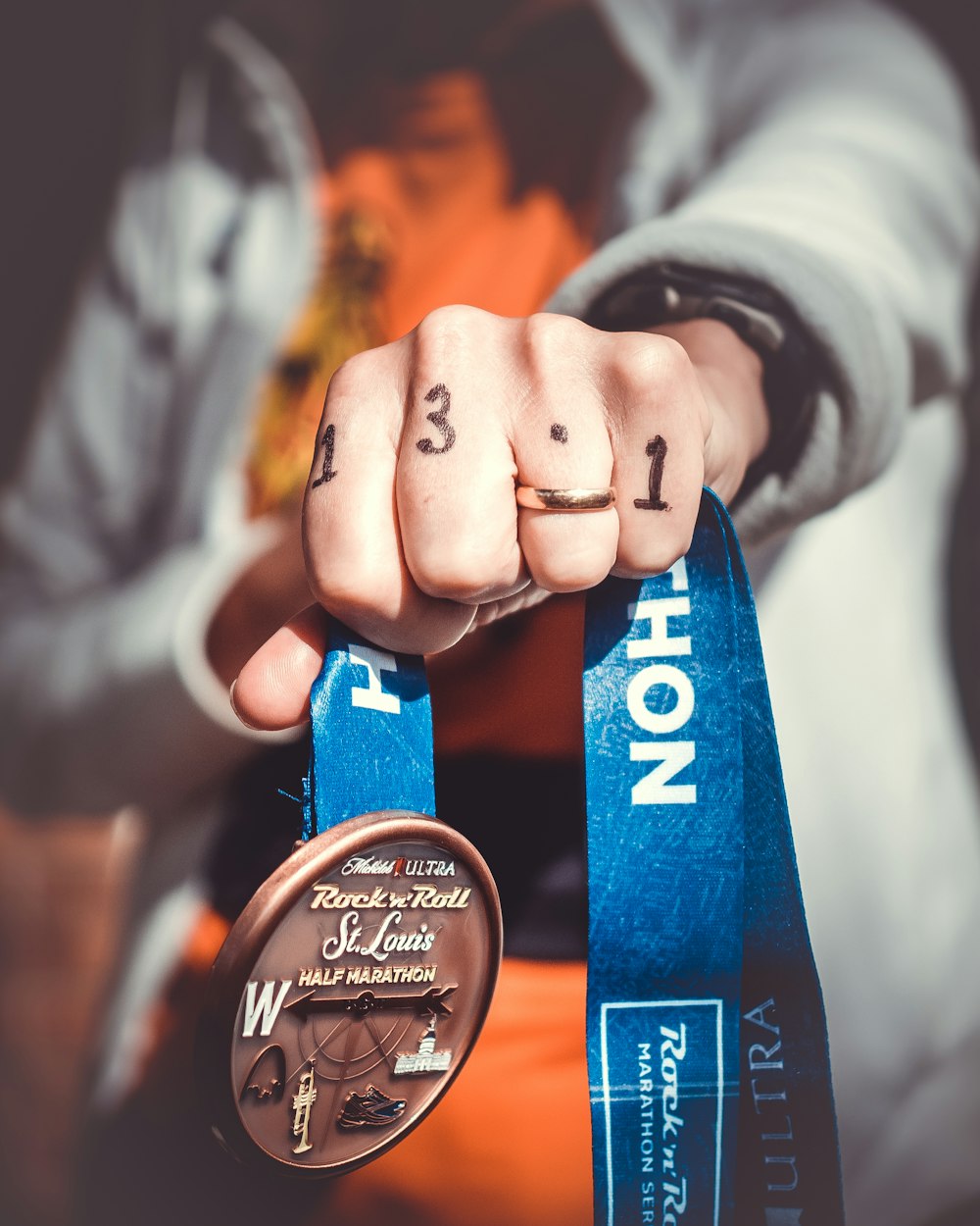 persona que sostiene la medalla de medio maratón de Rock N Roll St. Louis