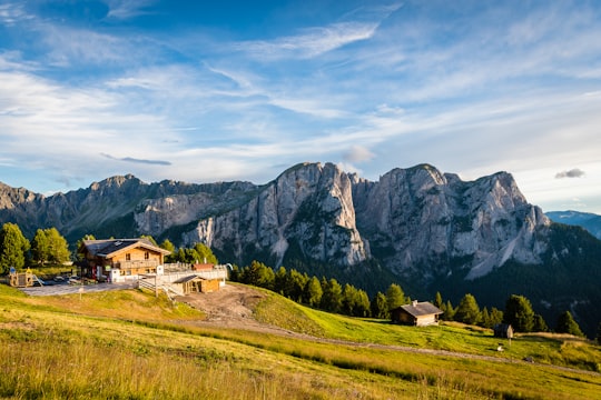 brown and white concrete house near mountain peak in Pozza di Fassa Italy