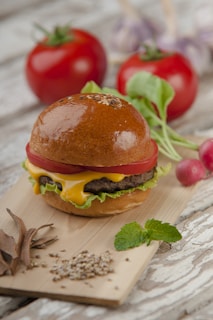 A premium sirloin hamburger with melted cheese and fresh lettuce on a rustic wooden board.