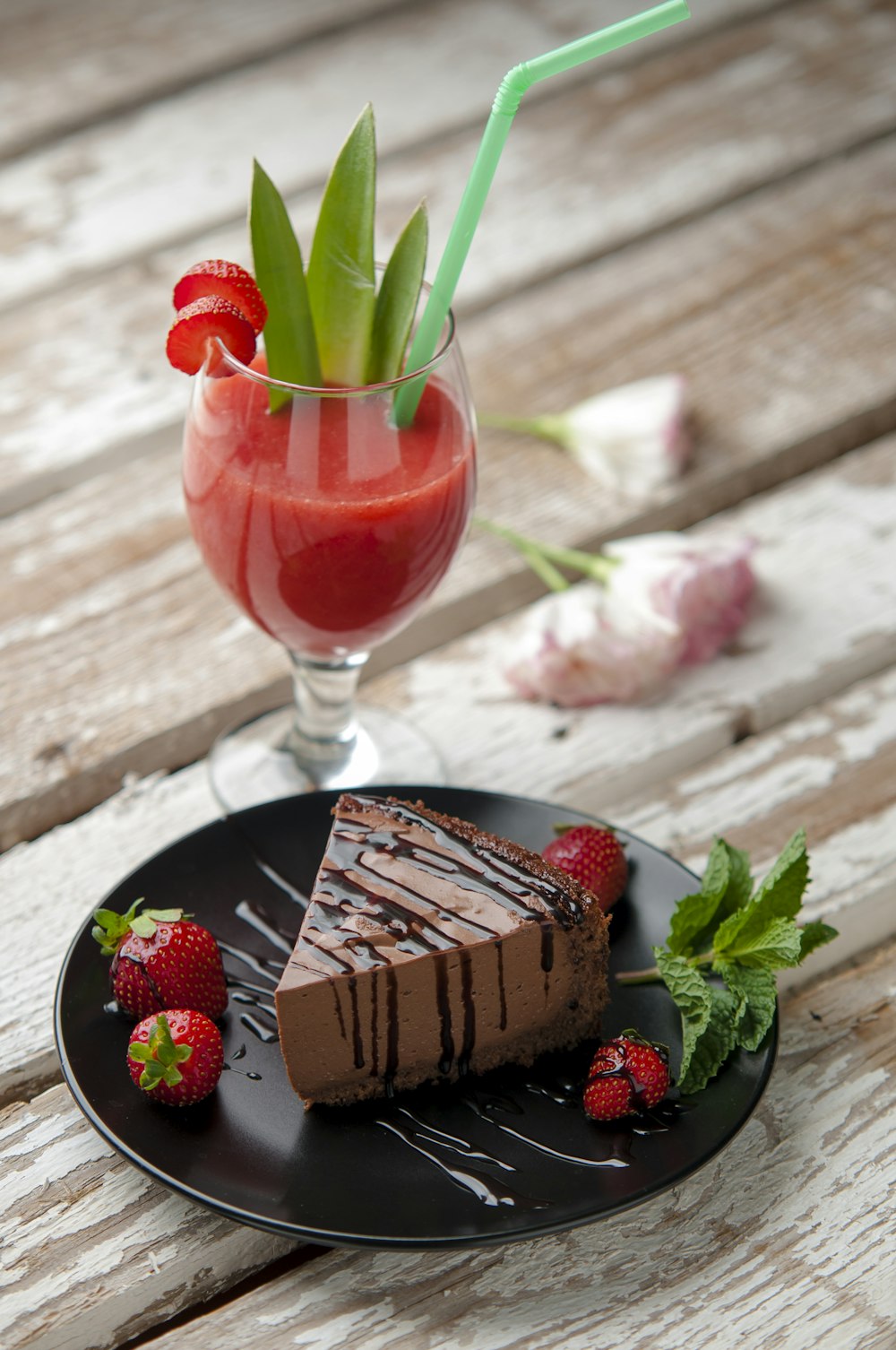 イチゴとワイングラスの横のチョコレートケーキ