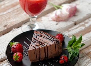 chocolate cake beside strawberries and wine glass