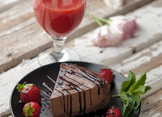 chocolate cake beside strawberries and wine glass