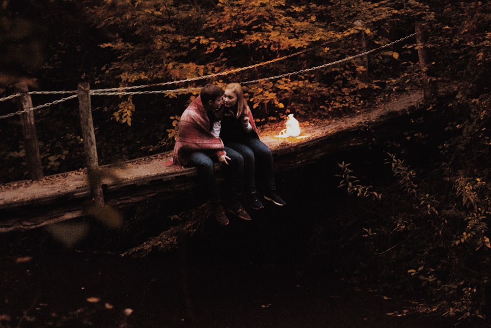 couple sitting on bridge