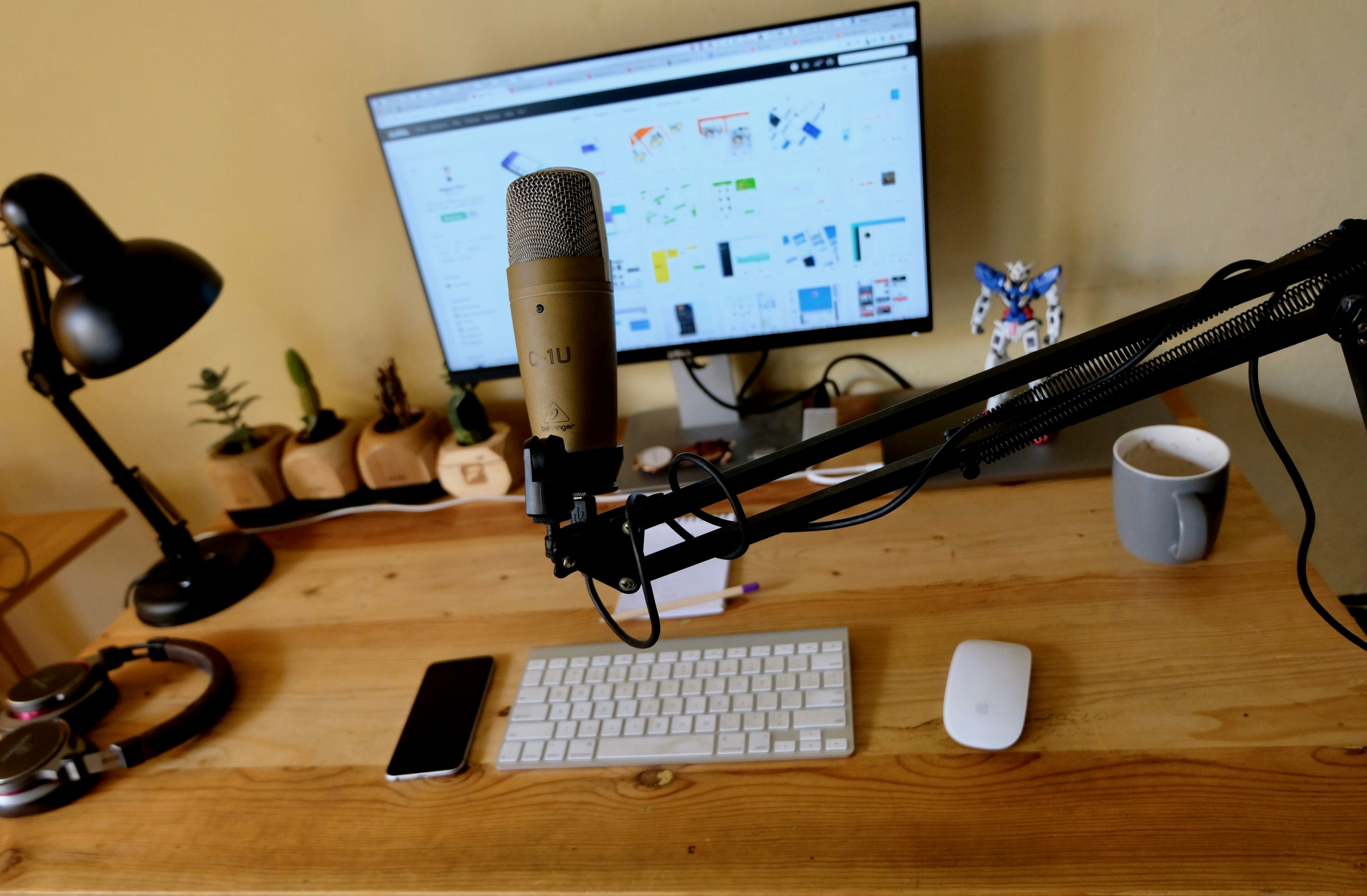 Podcaster recording in a well-lit studio with professional microphone setup, warm ambient light, clean desk environment