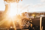 photo of music band performing at front of crowded stadium under blue sky