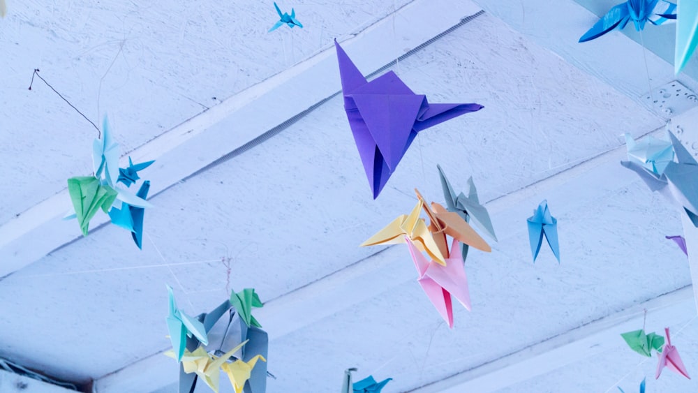 Origami-Papiere in verschiedenen Farben hängen an der Decke