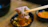 A close-up of a man savoring a vibrant, colorful Asian fusion meal with chopsticks in a stylish restaurant.